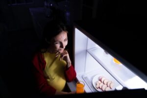 A pregnant woman who wakes up late at night looking for food in the refrigerator
